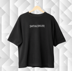 Black t-shirt with text on a white geometric patterned background